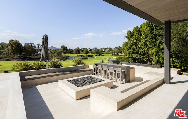 view of patio / terrace with an outdoor kitchen, a water view, an outdoor bar, and a fire pit