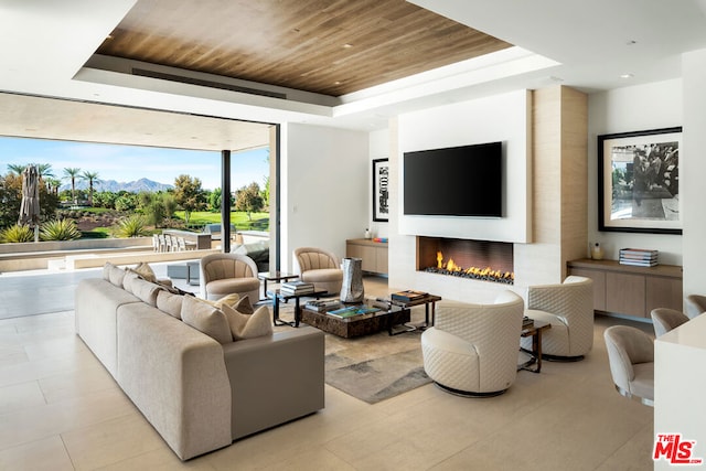 living room with wood ceiling and a tray ceiling