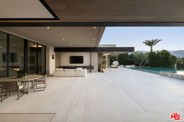 view of patio featuring a mountain view, pool water feature, and an outdoor hangout area