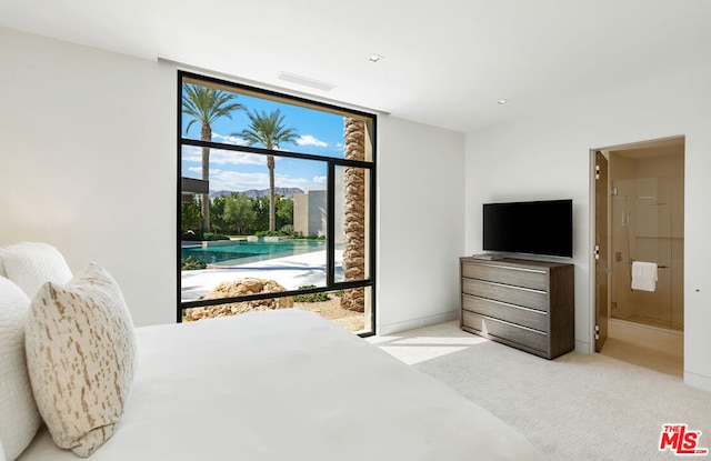 bedroom with light colored carpet and ensuite bath