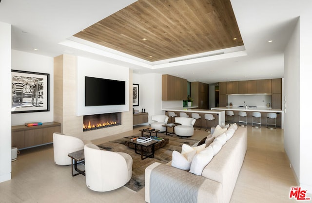 living room featuring a raised ceiling and wooden ceiling