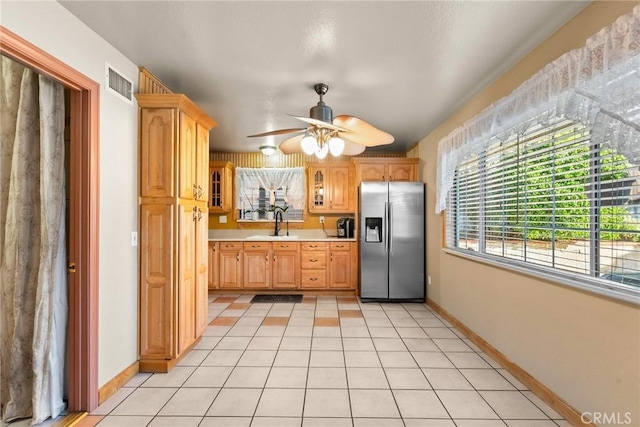 kitchen with ceiling fan, sink, light tile patterned floors, and stainless steel fridge with ice dispenser