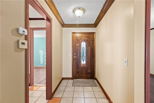 entrance foyer featuring a textured ceiling, light tile patterned floors, and ornamental molding