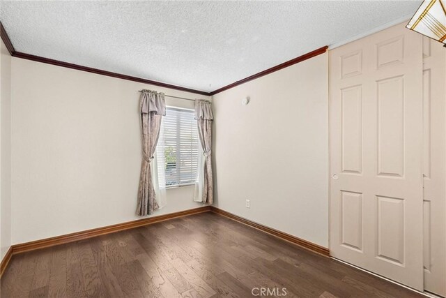 unfurnished room with a textured ceiling and dark hardwood / wood-style flooring