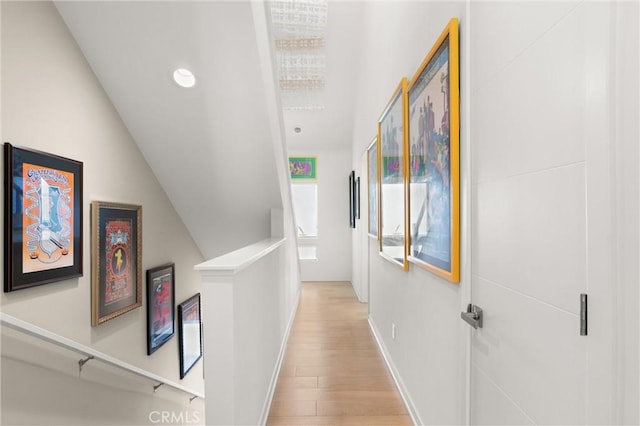 hallway featuring light hardwood / wood-style floors and vaulted ceiling