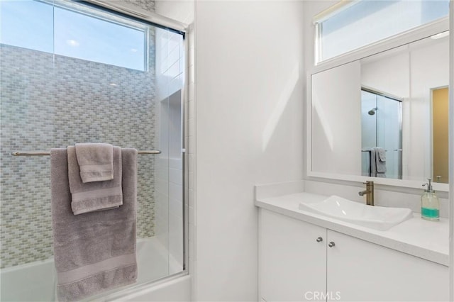 bathroom with vanity and shower / bath combination with glass door