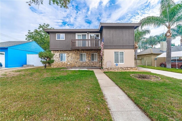 view of front of home with a front yard and a balcony