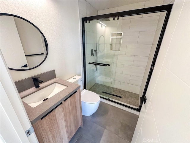 bathroom with vanity, toilet, and a shower with door