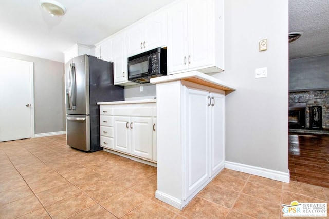 kitchen with white cabinets, stainless steel fridge, and light hardwood / wood-style floors