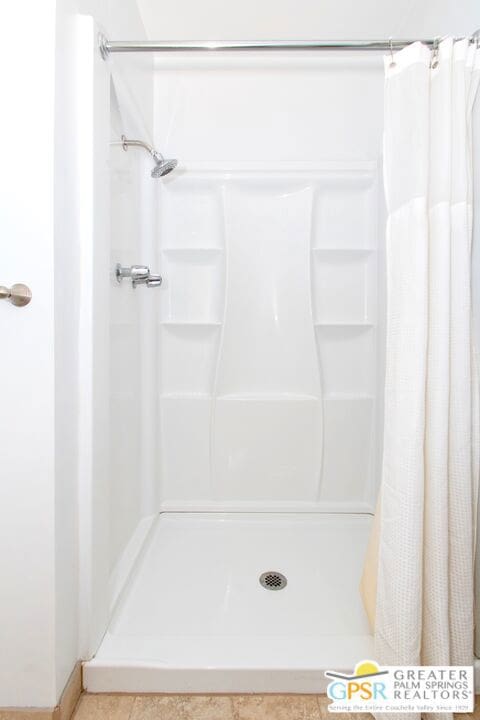 bathroom with a shower with curtain and tile patterned floors