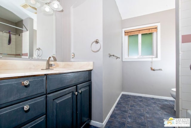 bathroom with toilet, vanity, and tile patterned floors