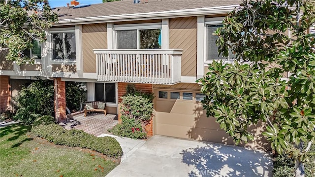 view of front of property featuring a balcony and a garage