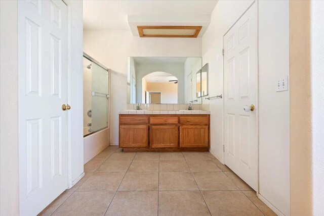 bathroom with tile patterned floors, vanity, and bath / shower combo with glass door