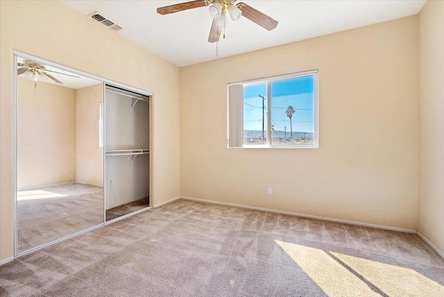 unfurnished bedroom featuring a closet, ceiling fan, and light colored carpet