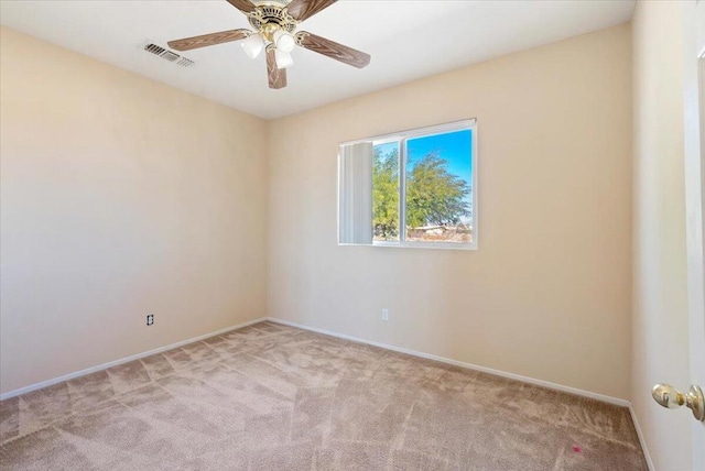 spare room with light colored carpet and ceiling fan