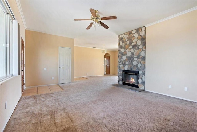 unfurnished living room with ceiling fan, light colored carpet, a fireplace, and crown molding