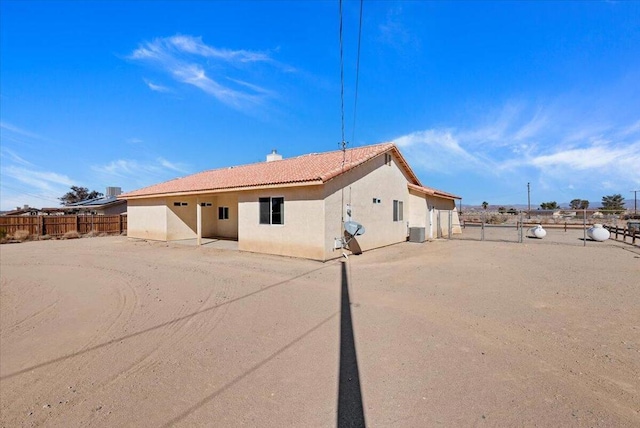 rear view of house featuring central AC