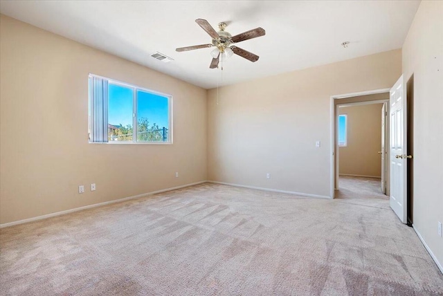 carpeted spare room featuring ceiling fan