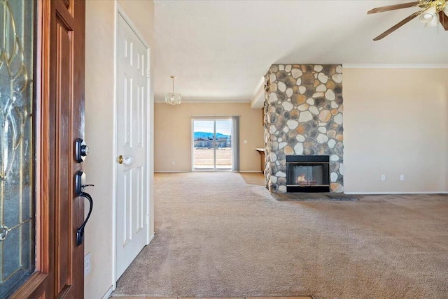 unfurnished living room featuring a stone fireplace, light colored carpet, and crown molding