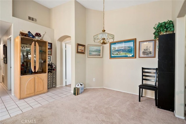 interior space with light colored carpet, high vaulted ceiling, and a notable chandelier