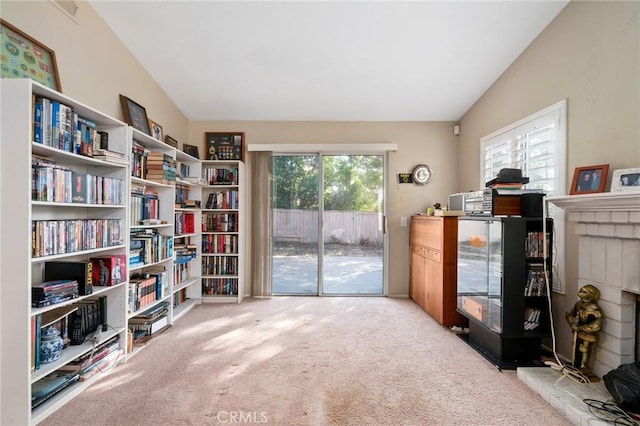 sitting room with light colored carpet, a fireplace, and vaulted ceiling