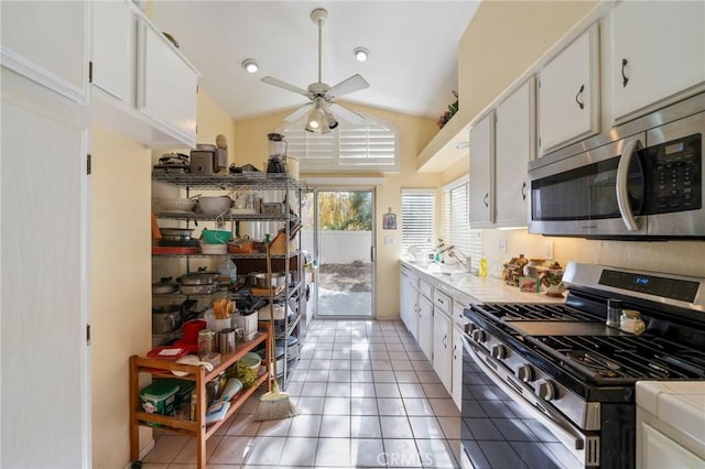 kitchen featuring lofted ceiling, white cabinetry, and stainless steel appliances