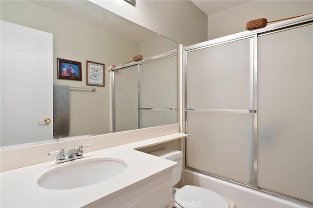 full bathroom featuring vanity, bath / shower combo with glass door, and toilet