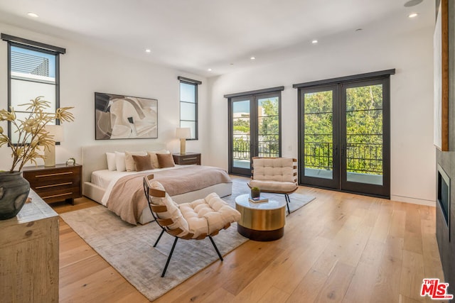 bedroom with french doors, access to outside, and multiple windows