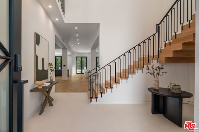 tiled foyer with a towering ceiling