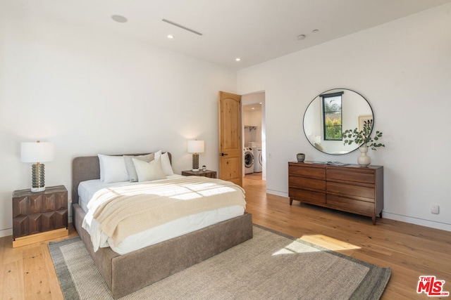 bedroom featuring washer / dryer and light wood-type flooring