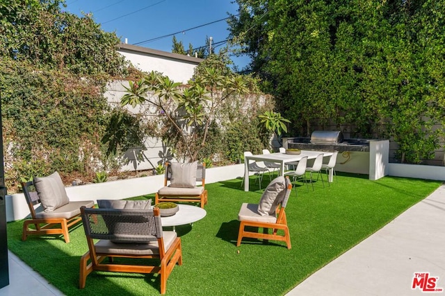 exterior space with a yard, an outdoor hangout area, and exterior kitchen