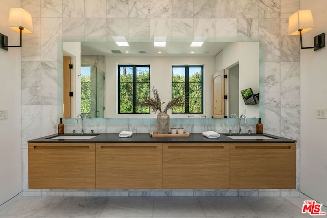 bathroom featuring vanity and tile walls