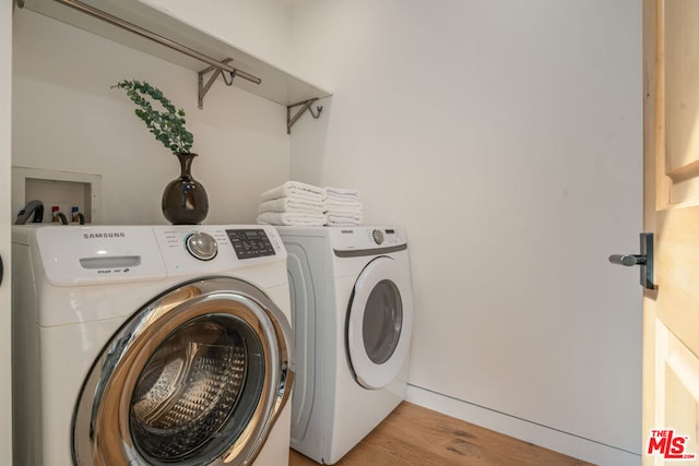 washroom with light wood-type flooring and washer and clothes dryer