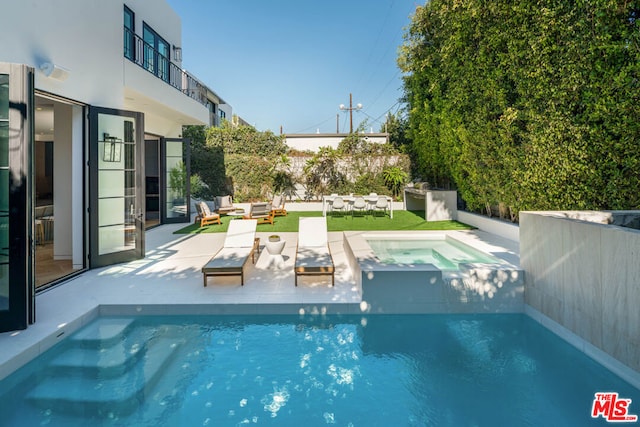 view of pool featuring an in ground hot tub, a patio, and an outdoor living space