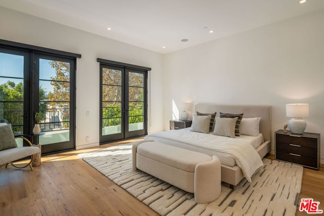 bedroom with access to exterior, light wood-type flooring, and french doors