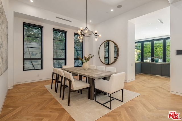 dining space featuring a chandelier and light parquet flooring