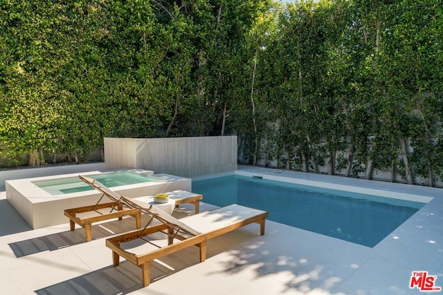 view of swimming pool featuring a patio area and an in ground hot tub