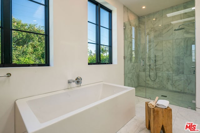 bathroom featuring shower with separate bathtub