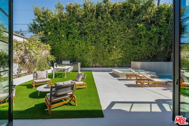 view of patio with an in ground hot tub