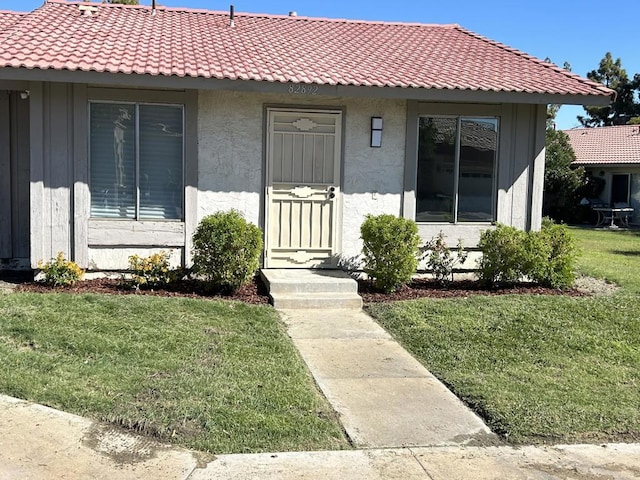 doorway to property with a lawn