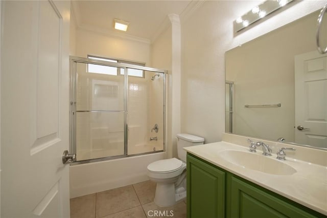 full bathroom with tile patterned floors, vanity, crown molding, shower / bath combination with glass door, and toilet