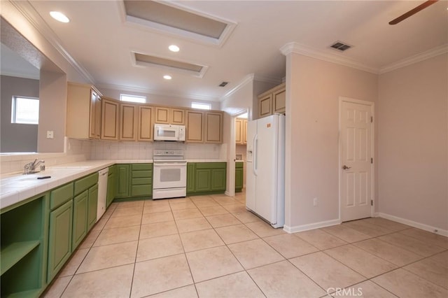 kitchen with decorative backsplash, tile counters, crown molding, and white appliances