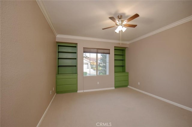 carpeted empty room featuring ceiling fan and ornamental molding