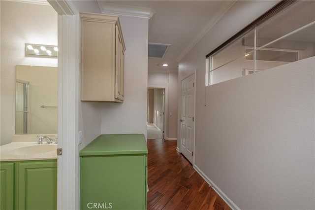 hallway featuring dark hardwood / wood-style floors, ornamental molding, and sink