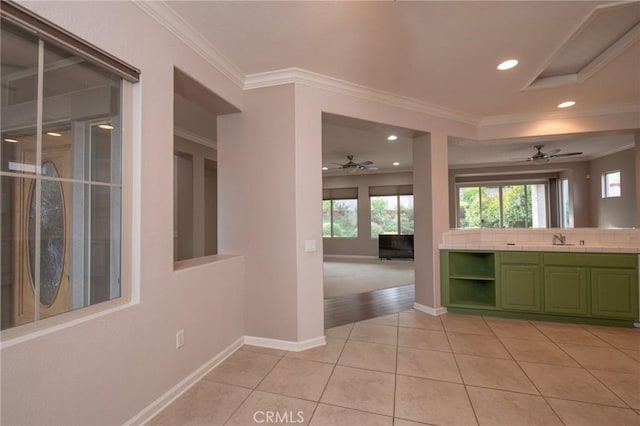 kitchen featuring tile countertops, sink, crown molding, ceiling fan, and light tile patterned floors