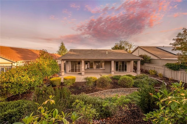 back house at dusk with a patio area