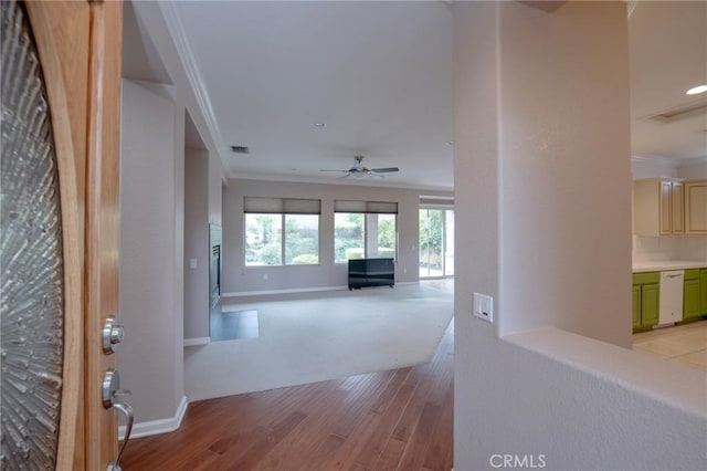 hallway with light hardwood / wood-style flooring and ornamental molding