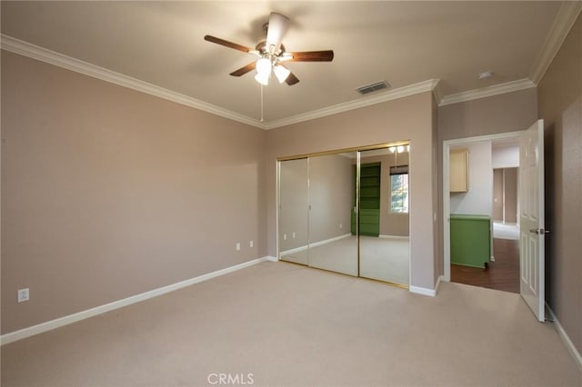 unfurnished bedroom featuring ceiling fan, a closet, carpet, and ornamental molding