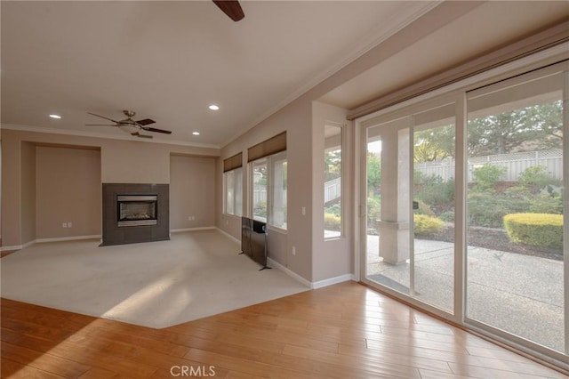 interior space with crown molding, ceiling fan, and light wood-type flooring