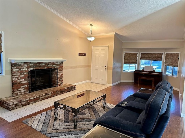 living room with hardwood / wood-style floors, a textured ceiling, a brick fireplace, and ornamental molding